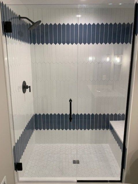 Frameless shower with matte black hardware and blue scalloped tile