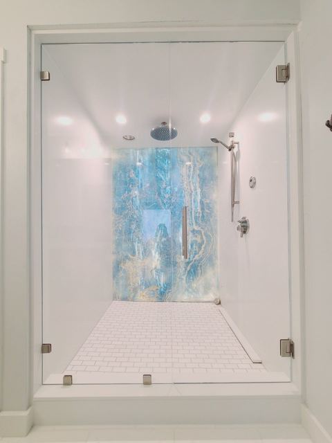 Frameless shower framing a blue feature wall
