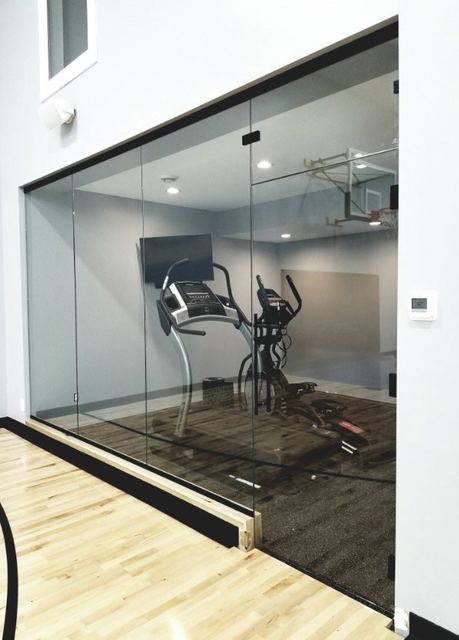 Frameless glass wall enclosing a home gym