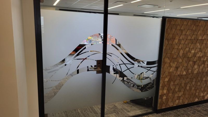 Custom etched film graphic across an office glass partition