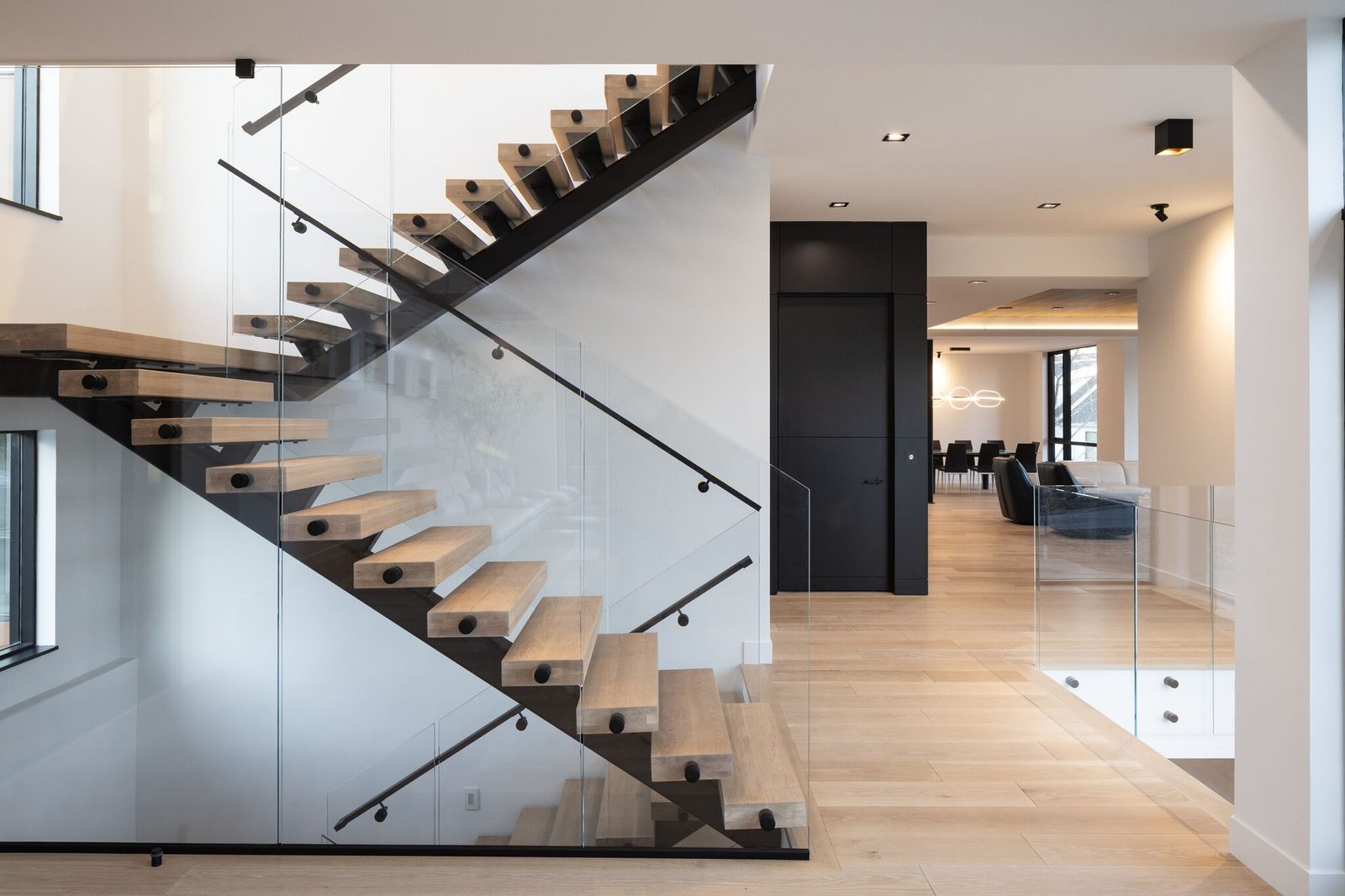 Frameless glass railing along an open staircase and landing