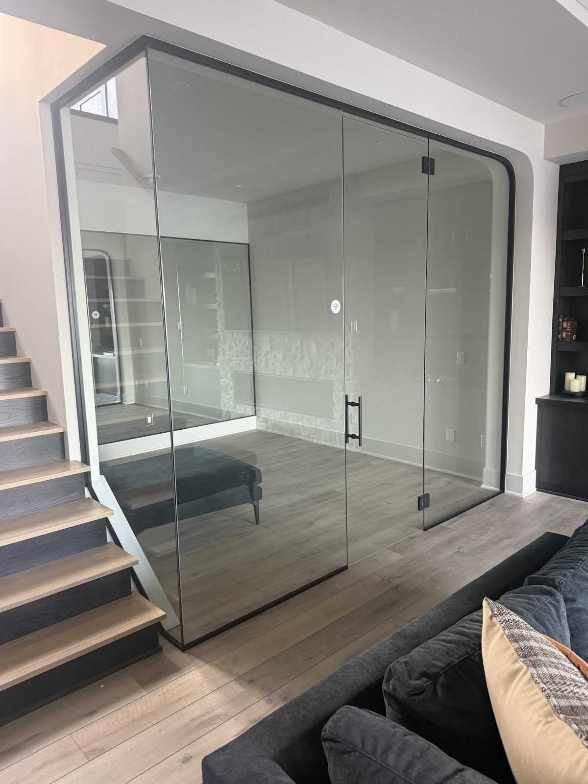 Frameless glass wall and door enclosing a home gym