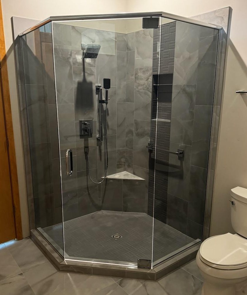 Gray tinted neo-angle shower with the lights on