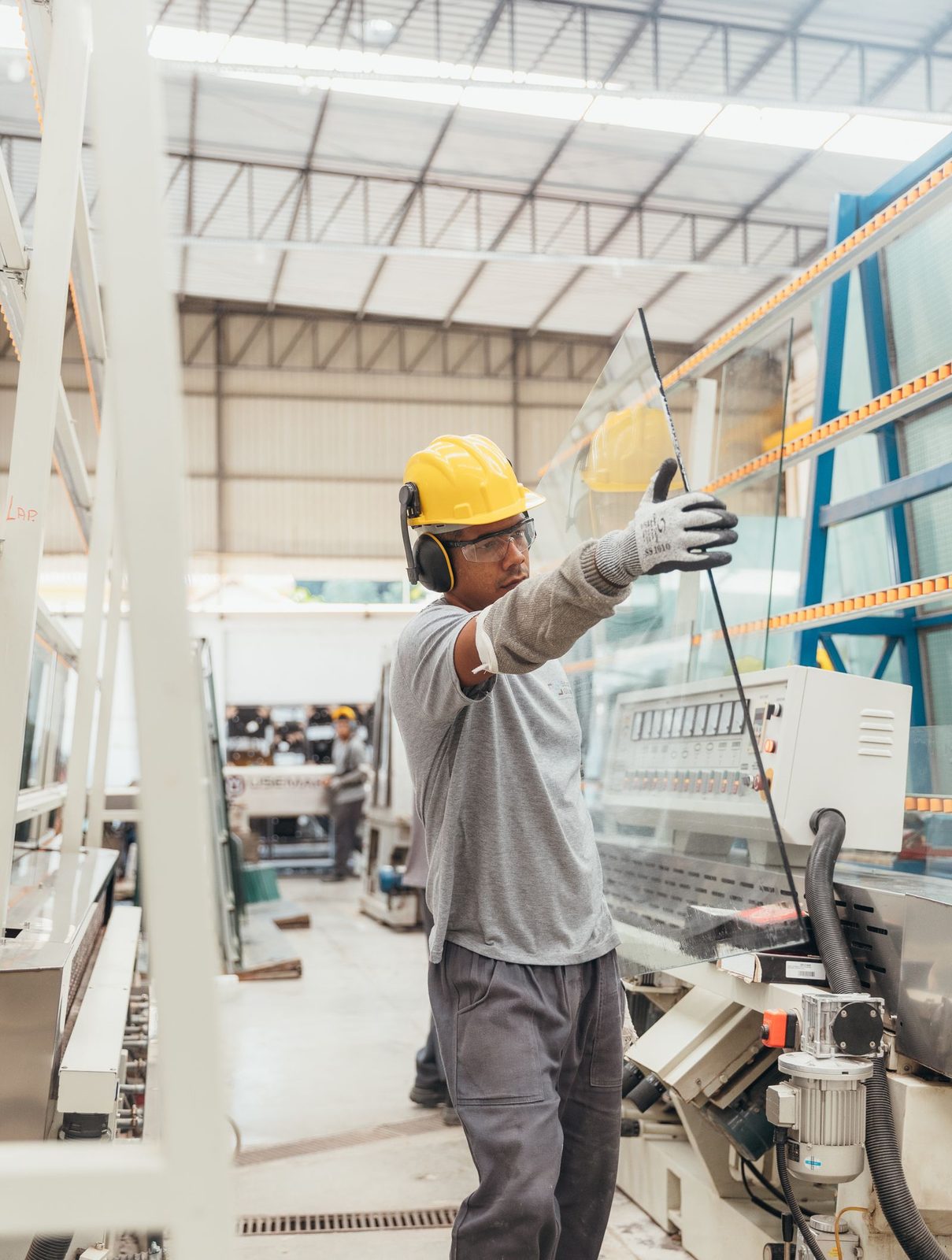 Glass fabricator handling a large sheet on the shop floor